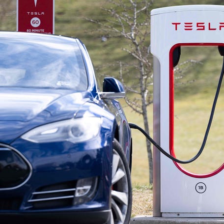 A Tesla Model S sedan is plugged into a Tesla Supercharger electrical vehicle charging station in Falls Church, Virginia on Feb. 13, 2023.