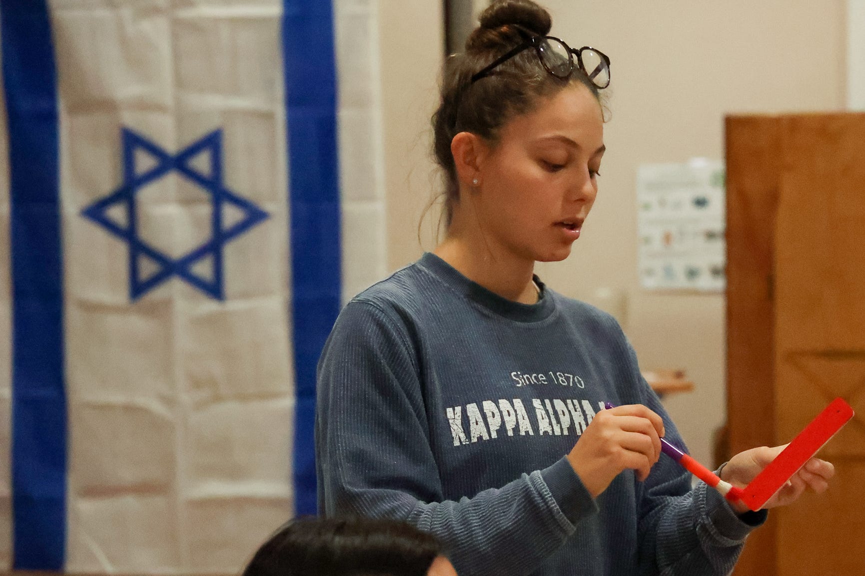 Kaylee Werner, a co-chair of the anti-semitism taskforce at Indiana University Hillel, leads the taskforce meeting on Tuesday October 11th. The task force meeting was led while painting mezzuzahs red to pass out to students.