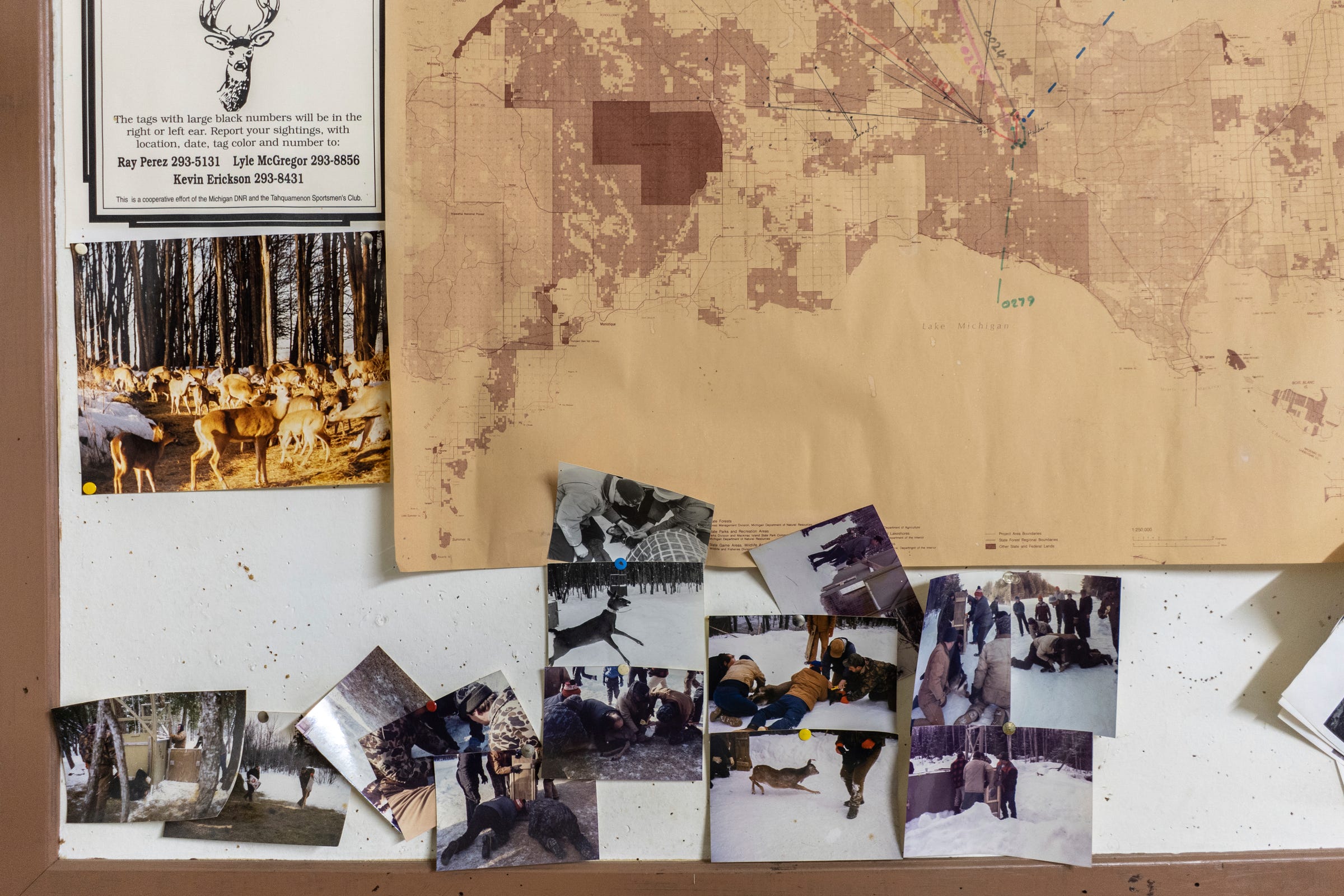 Old photos and maps tacked to a wall at the Tahquamenon Sportsmen's Club in Newberry on Saturday, April 22, 2023, in Michigan's Upper Peninsula.