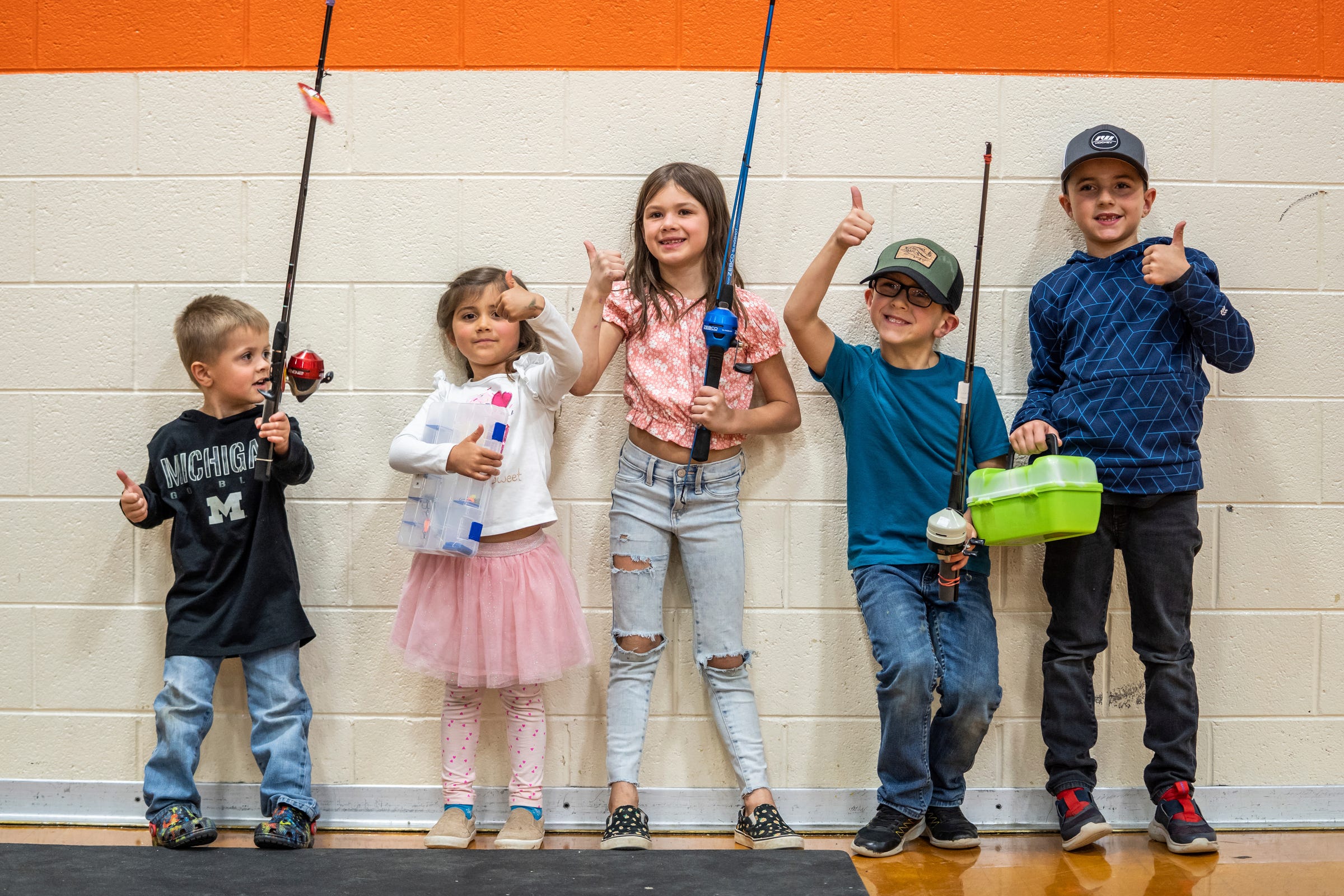 Oliver Clickner, left, Brynlee Bruno, Brielle Chamberlain, Liam McNamara and Mason Green McNamara, all of Newberry, pose for a photo taken by their parents during the 65th annual Kids Tackle Party at Newberry High School put on by the Tahquamenon Sportsmen's Club in Newberry on Saturday, April 22, 2023, in Michigan's Upper Peninsula.