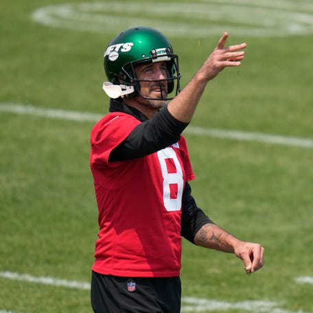 New York Jets quarterback Aaron Rodgers throws grass in the air at the NFL football team's training facility in Florham Park, N.J., Tuesday, June 6, 2023.