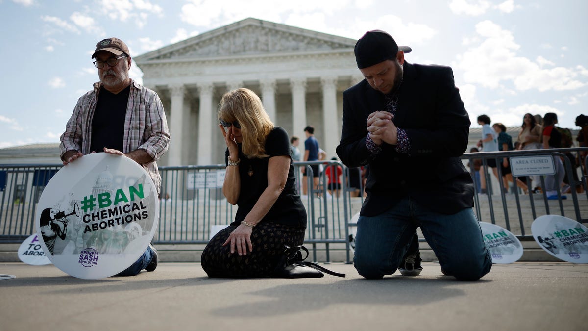WASHINGTON, DC - APRIL 21: (L-R) Rev. Pat Mahoney, Peggy Nienaber of Faith and Liberty and Mark Lee Dickson of Right to Life East Texas pray in front of the U.S. Supreme Court on April 21, 2023 in Washington, DC. Organized by The Stanton Public Policy Center/Purple Sash Revolution, the small group of demonstrators called on the Supreme Court to affirm Federal District Court Judge Matthew Kacsmaryk's ruling that suspends the Food and Drug Administration's   approval of the abortion pill mifepristone. (Photo by Chip Somodevilla/Getty Images) ORG XMIT: 775968886 ORIG FILE ID: 1483862729