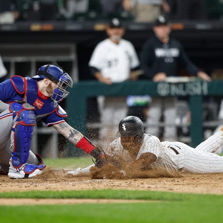Chicago White Sox shortstop Elvis Andrus slides into home in the eighth inning as Texas Rangers catcher Jonah Heim applies a tag.
