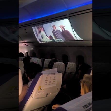 'He's chilling': Man projects personal in-flight movie on overhead bin