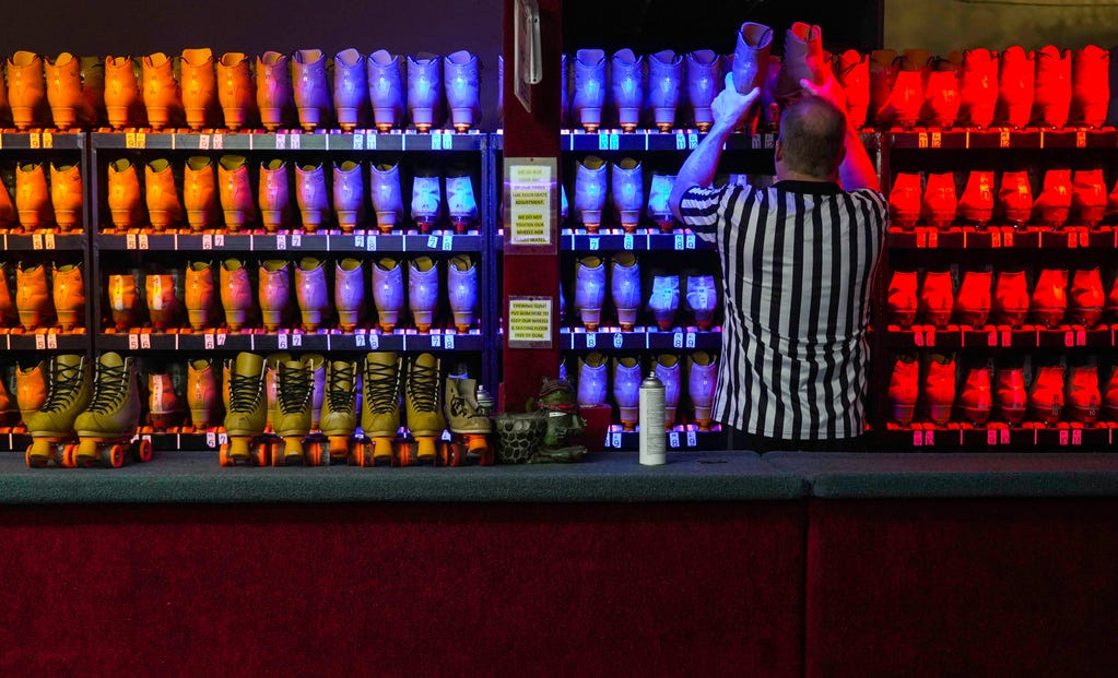 An employee at Moonlight Rollerway in Glendale, Calif., puts used roller skates back on the racks. The skating rink hosted Rainbow Skate Night on June 14, 2023.