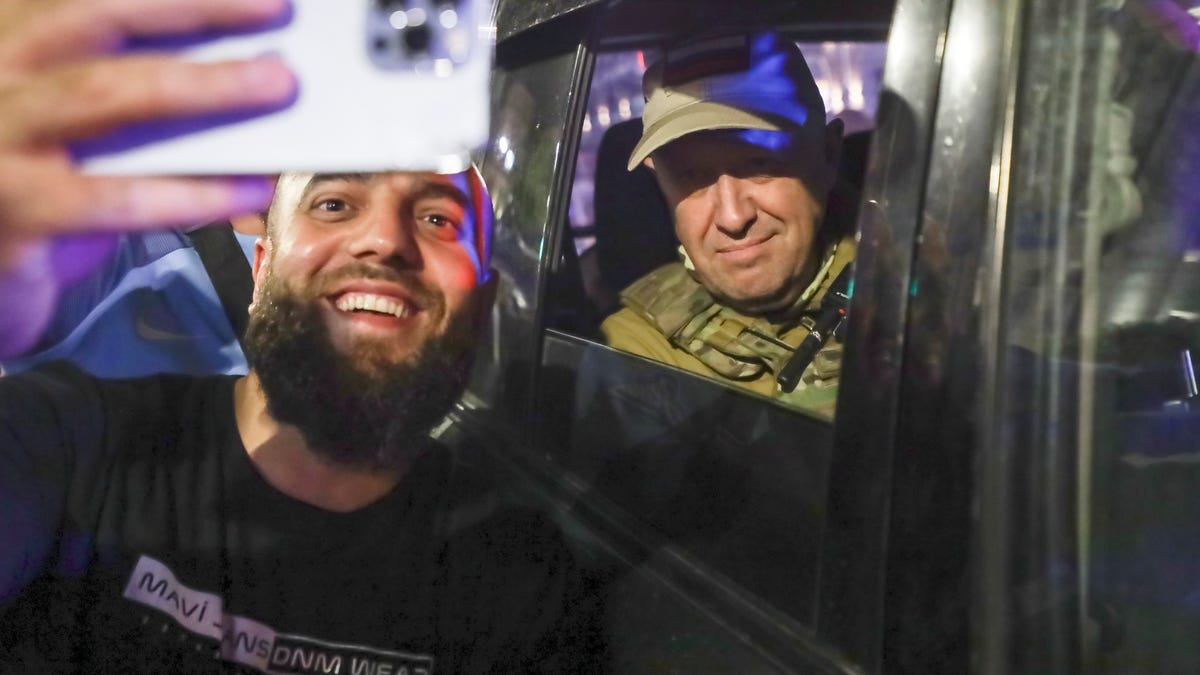 Yevgeny Prigozhin, the owner of the Wagner Group military company, right, sits inside a military vehicle posing for a selfie photo with a local civilian on a street in Rostov-on-Don, Russia, Saturday, June 24, 2023, prior to leaving an area of the headquarters of the Southern Military District. (AP Photo) ORG XMIT: XAZ164