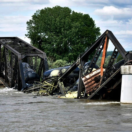 Several train cars are immersed in the Yellowstone River after a bridge collapse near Columbus, Mont., on Saturday, June 24, 2023. The bridge collapsed overnight, causing a train that was traveling over it to plunge into the water below.