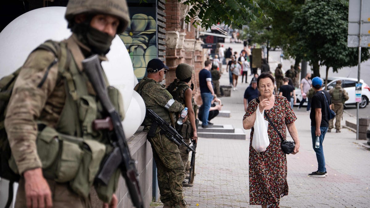 A local resident walks past members of Wagner group in Rostov-on-Don, on June 24, 2023. President Vladimir Putin on June 24, 2023 said an armed mutiny by Wagner mercenaries was a "stab in the back" and that the group's chief Yevgeny Prigozhin had betrayed Russia, as he vowed to punish the dissidents. Prigozhin said his fighters control key military sites in the southern city of Rostov-on-Don.