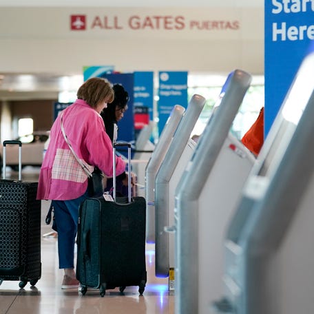 Travelers use the kiosk by the ticketing gate as they prepare for travel from Love Field airport, May 19, 2023, in Dallas.