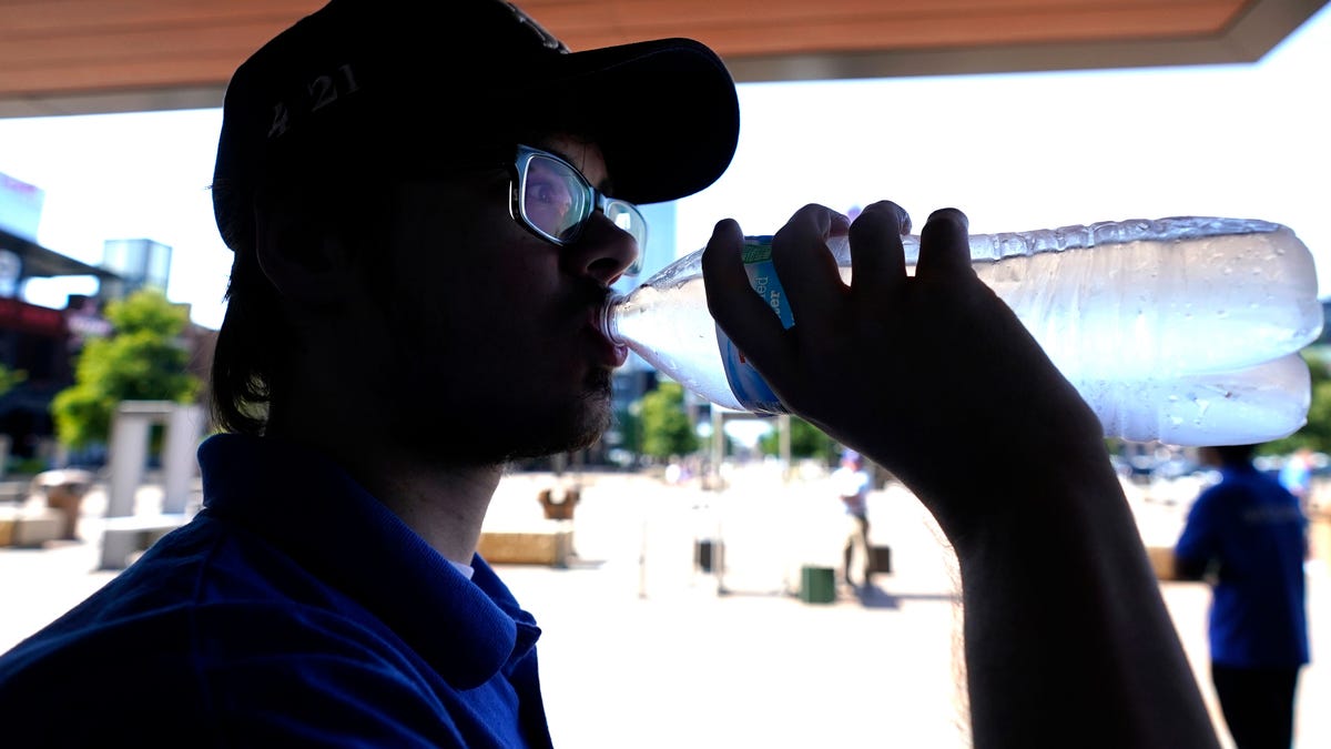 Nathan Darr drinks water while working security outside in Arlington, Texas, Monday, June 26, 2023.