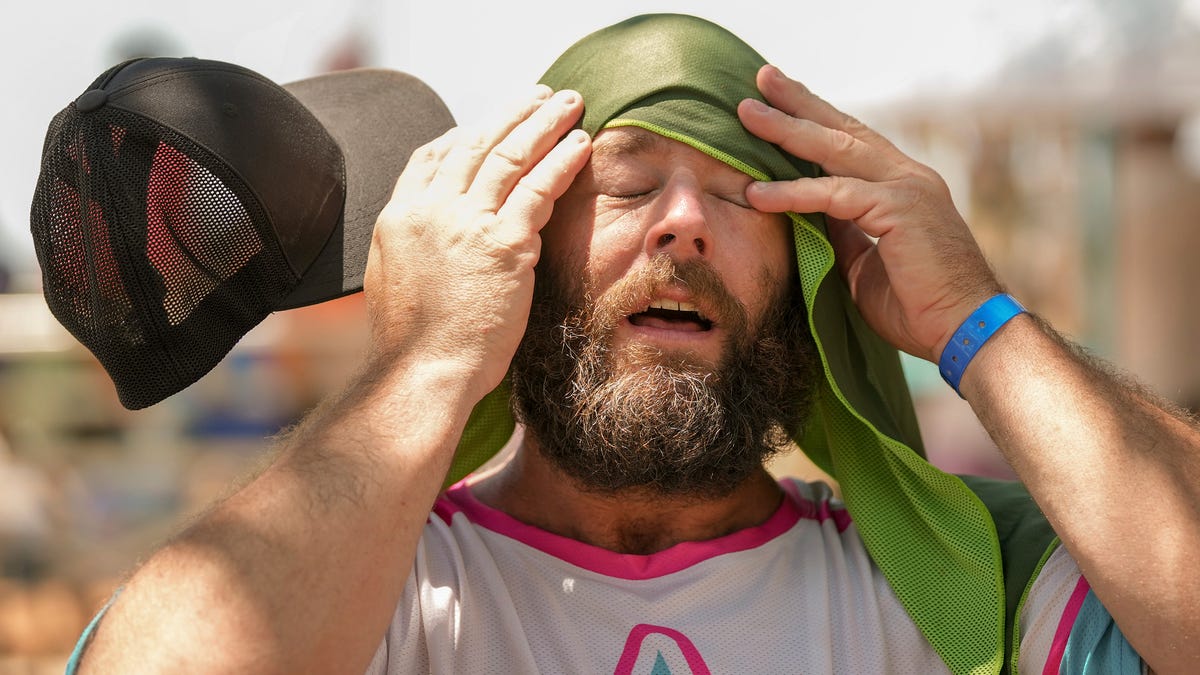 Shane Mullen, of Austin, cools off with a towel soaked in ice water at the Southwest Softball Association for the Deaf regional tournament at Walnut Creek Metropolitan Park in Austin, Texas, on a hot afternoon Friday June 23, 2023.