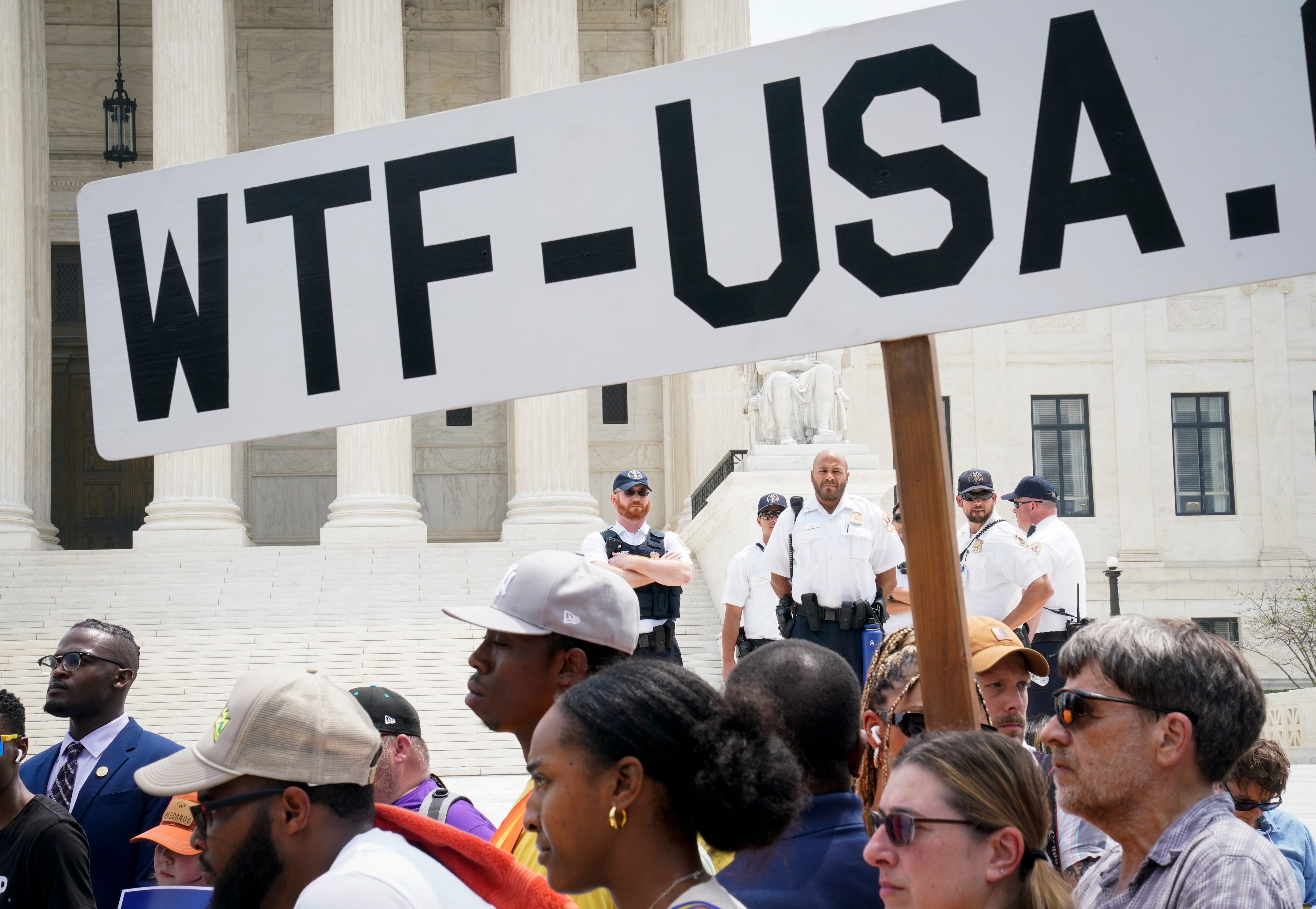 A protester against student debt forgiveness carries a sign and chants "Pay your bills," at the Supreme Court on June 30, 2023.
