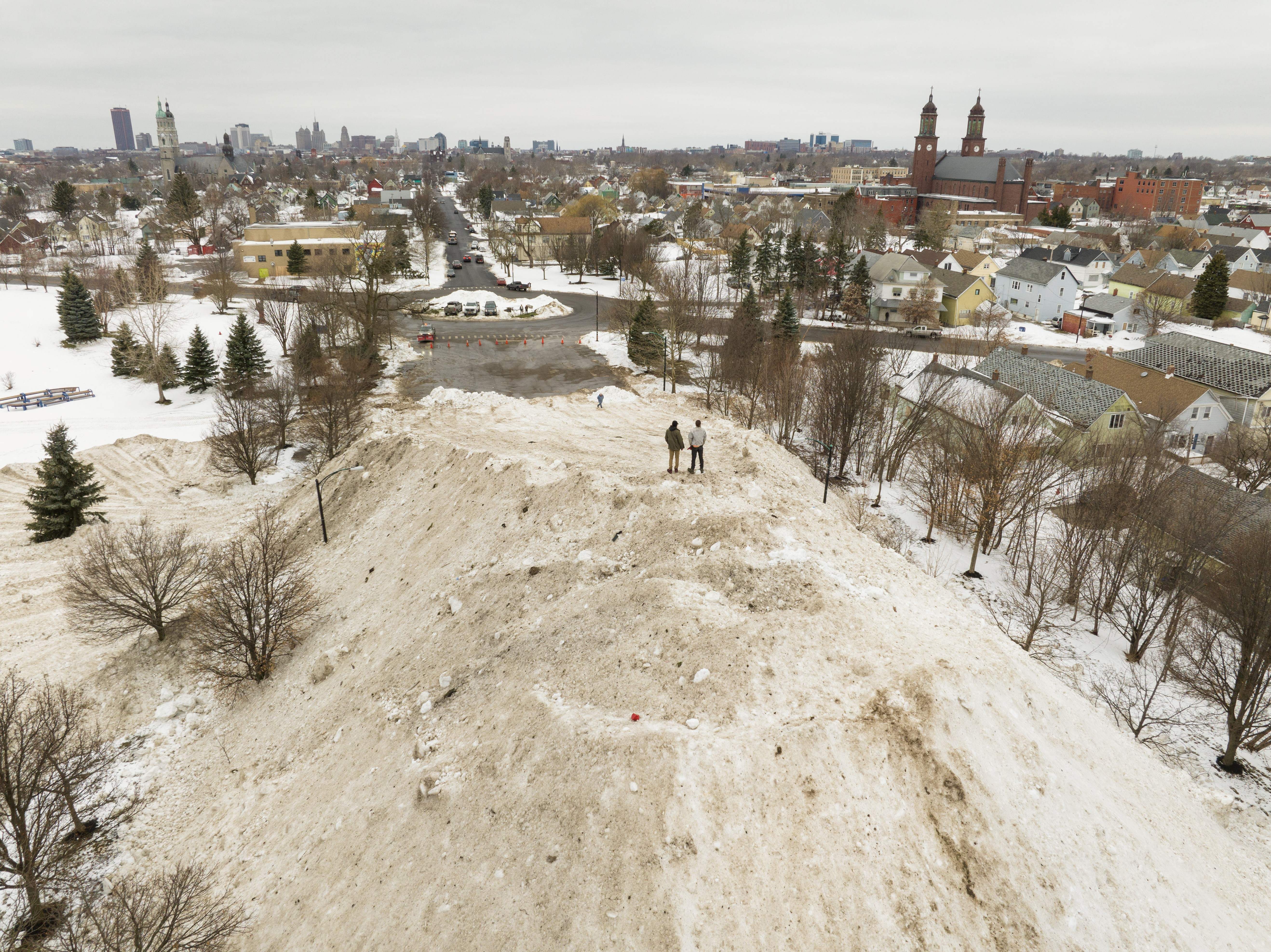 Residents take in the view from atop a gigantic snow pile in front of Central Terminal in Buffalo, New York, on December 29, 2022.