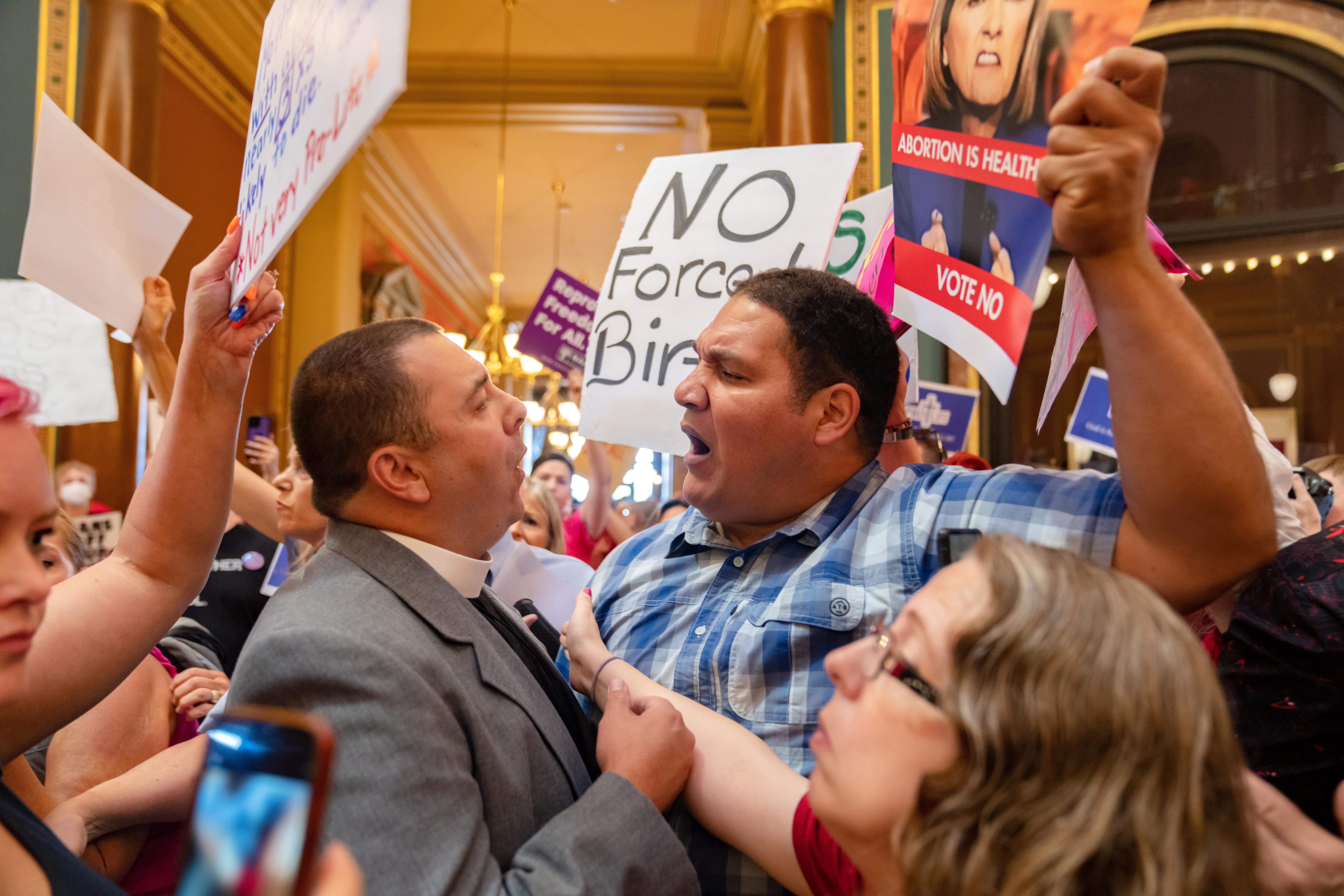 The Rev. Michael Shover of Christ the Redeemer Church in Pella, Iowa, left, argues with Ryan Maher, of Des Moines, as anti-abortion and pro-choice protesters clash in the Iowa Capitol rotunda while the state legislature convenes for a special session to pass a 'fetal heartbeat' ban on July 11, 2023.