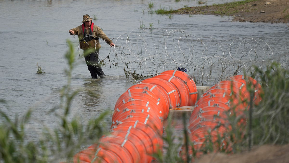 July 11, 2023: Workers assemble large buoys to be used as a border barrier along the banks of the Rio Grande in Eagle Pass , Texas. The floating barrier is being deployed in an effort to block migrants from entering Texas from Mexico.