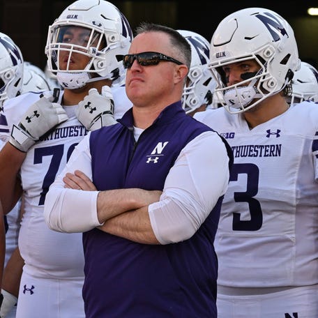 Northwestern coach Pat Fitzgerald stands with his team prior to their game against Iowa at Kinnick Stadium.