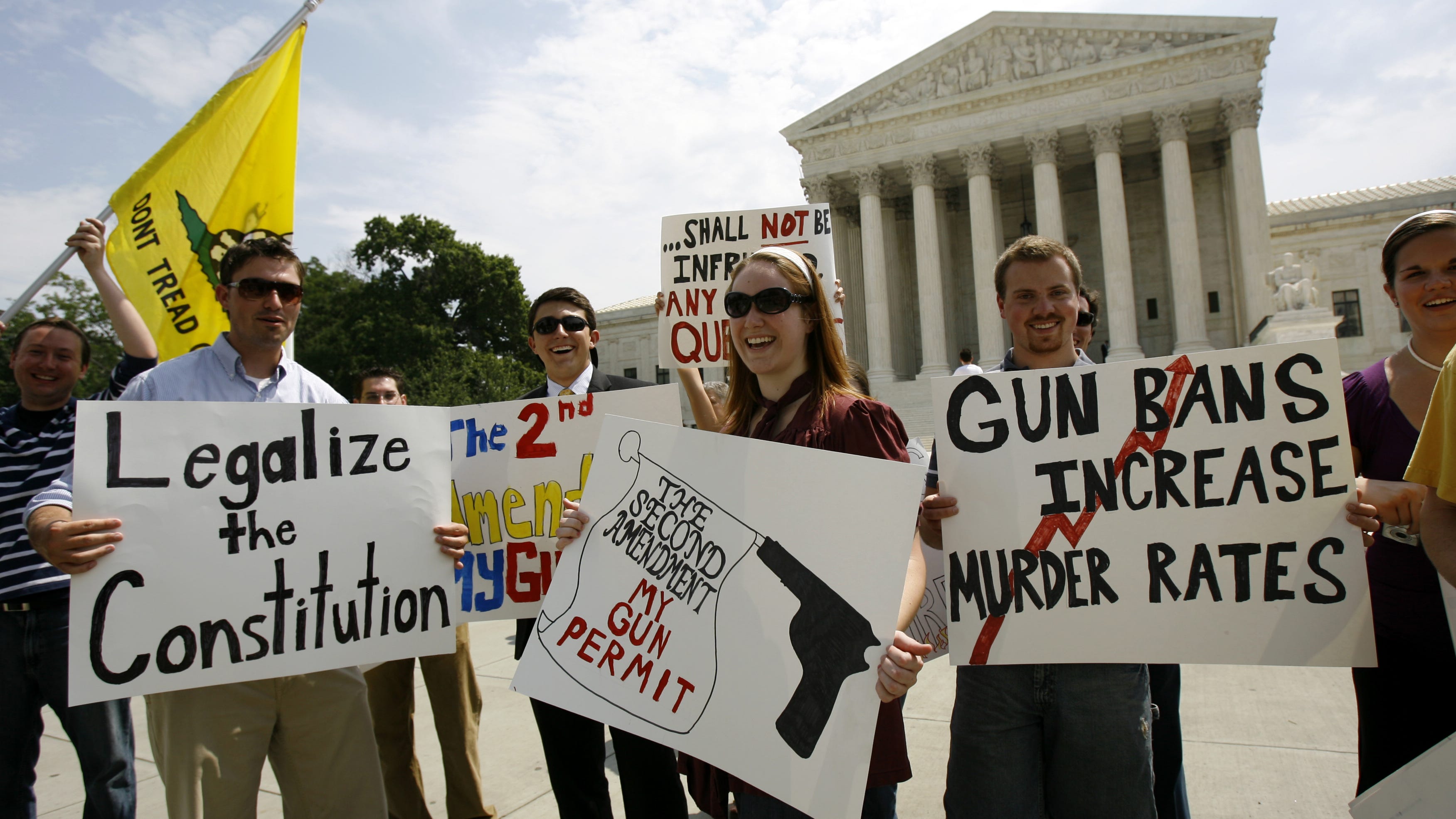 Pro-rights gun supporters hold up their banners outside the Supreme Court in Washington on June 26, 2008, after the court ruled that Americans have a constitutional right to keep guns in their homes for self-defense, the justices' first major pronouncement on gun control in U.S. history.