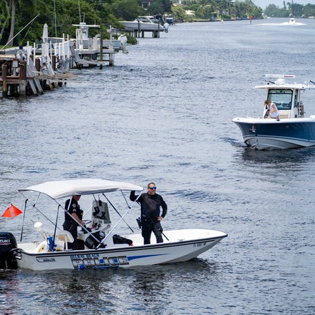 Delray Beach police keep boats away from a diver looking  for evidence near the bridge on George Bush Blvd. in Delray Beach, Florida on July 22, 2023. On Friday, police found three suitcases with human remains inside.