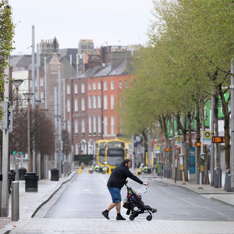 A man pushes a buggy across O'Connell Street in Dublin's city centre in Dublin, Ireland, Sunday April 12, 2020.