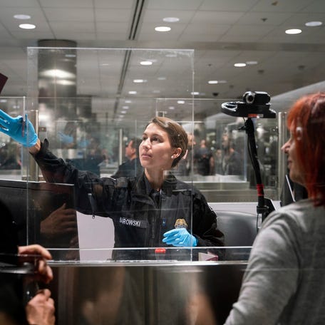CBP officer G. Barowski, center, screens international travelers Henning Radtke, left, and Jeanette Radtke upon entering U.S. Customs and Border Protection at McNamara Terminal at Detroit Metro Airport in Romulus on Friday, July 28, 2023.