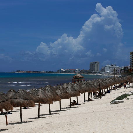 Tourists enjoy the beach in Cancun, Quintana Roo State, Mexico, Wednesday, Aug. 18, 2021.