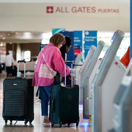 Travelers use the kiosk by the ticketing gate as they prepare for travel from Love Field airport, May 19, 2023, in Dallas.