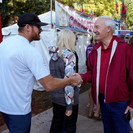 Republican presidential candidate former Arkansas Gov. Asa Hutchinson greets a fairgoer during a visit to the Iowa State Fair, Tuesday, Aug. 15, 2023, in Des Moines, Iowa. (AP Photo/Charlie Neibergall) ORG XMIT: IACN102