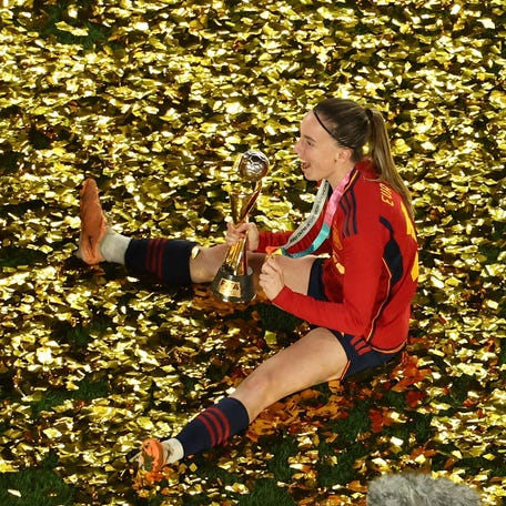 Spain's forward #15 Eva Navarro sits with the trophy amongst glitter as she celebrates winning the Australia and New Zealand 2023 Women's World Cup final football match between Spain and England at Stadium Australia in Sydney on August 20, 2023. (Photo by DAVID GRAY / AFP) (Photo by DAVID GRAY/AFP via Getty Images) ORIG FILE ID: AFP_33RU7HY.jpg
