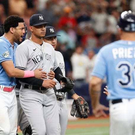 Tampa Bay Rays' Jose Siri, left, holds on to New York Yankees relief pitcher Albert Abreu during the eighth inning of a baseball game Sunday, Aug. 27, 2023, in St. Petersburg, Fla. (AP Photo/Scott Audette)
