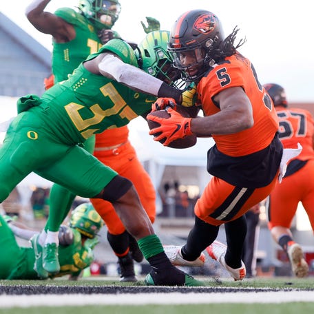 Oregon State running back Deshaun Fenwick (5) dives into the end zone to score a touchdown against Oregon during the second half at Reser Stadium.