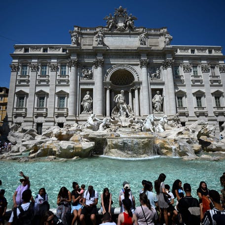 Tourists refresh themselves at the Trevi Fountain during a heat wave in Rome on Aug. 21 2023.