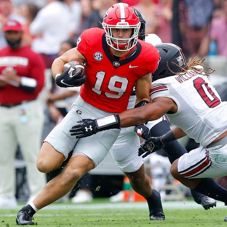 Georgia tight end Brock Bowers is tackled by South Carolina's Debo Williams during the first half at Sanford Stadium.