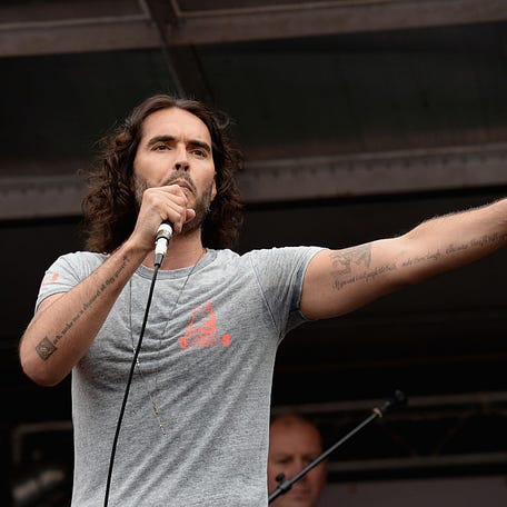 LONDON, ENGLAND - JUNE 20:  Comedian Russell Brand speaks to thousands of demonstrators gathered in Parliament Square to protest against austerity and spending cuts on June 20, 2015 in London, England. Thousands of people gathered to march from the City of London to Westminster, where they listened to addresses from singer Charlotte Church and comedian Russell Brand as well as Len McCluskey, general secretary of Unite and Sinn Fein's Martin McGuinness.    (Photo by Mary Turner/Getty Images)