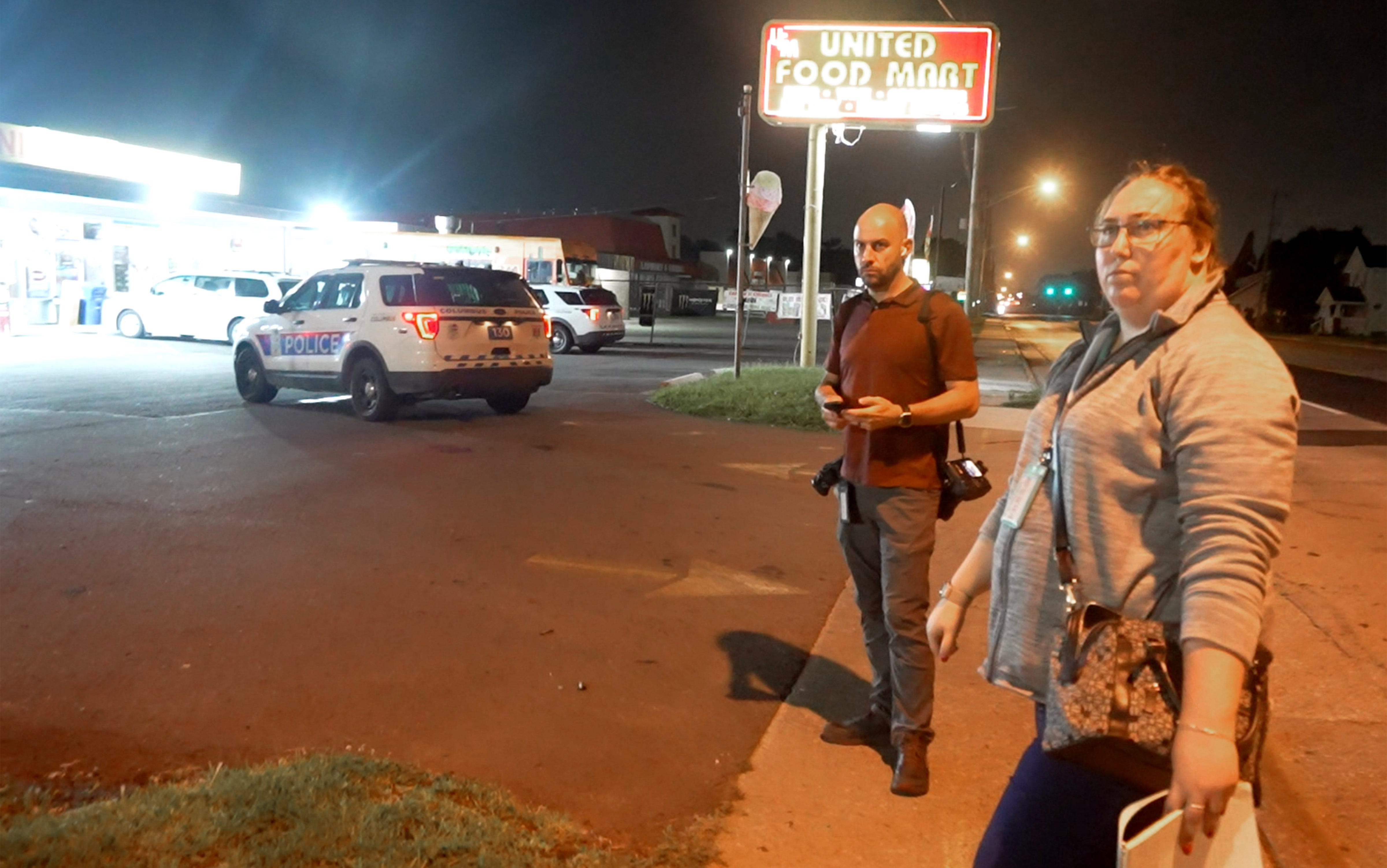 July 20, 2023 Columbus, Ohio, USA; At about 3 am Columbus Dispatch photographer Adam Cairns and reporter Bethany Bruner watch police investigate an armed robbery at the United Food Mart on S. High St.