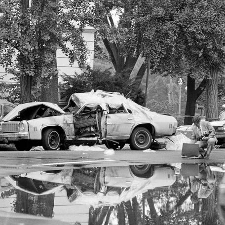 A car is covered with a protective material as police investigators probe the cause of a blast that killed Chilean diplomat Orlando Letelier and 25-year-old Ronni Moffitt on Sept. 21, 1976, in Washington, D.C.