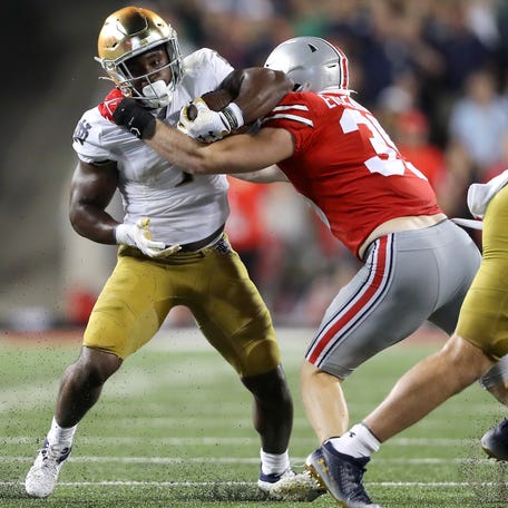 Notre Dame running back Audric Estime (7) runs the ball as Ohio State defensive end Jack Sawyer (33) makes the tackle during the third quarter at Ohio Stadium.