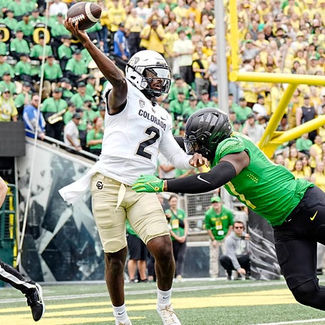 Colorado quarterback Shedeur Sanders (2) throws a pass while under pressure from Oregon linebacker Blake Purchase (17) during the first half at Autzen Stadium.