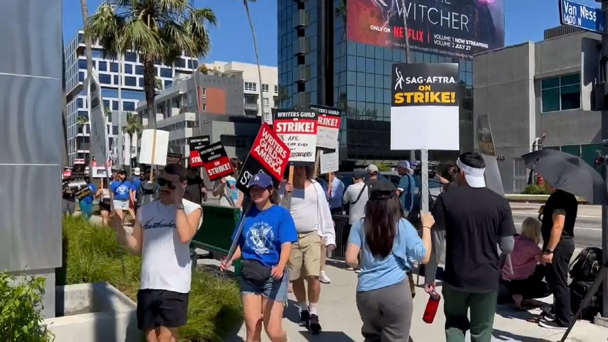 Writers' Guild and SGA-AFTRA members picket in front of Netflix's studio during their strike.