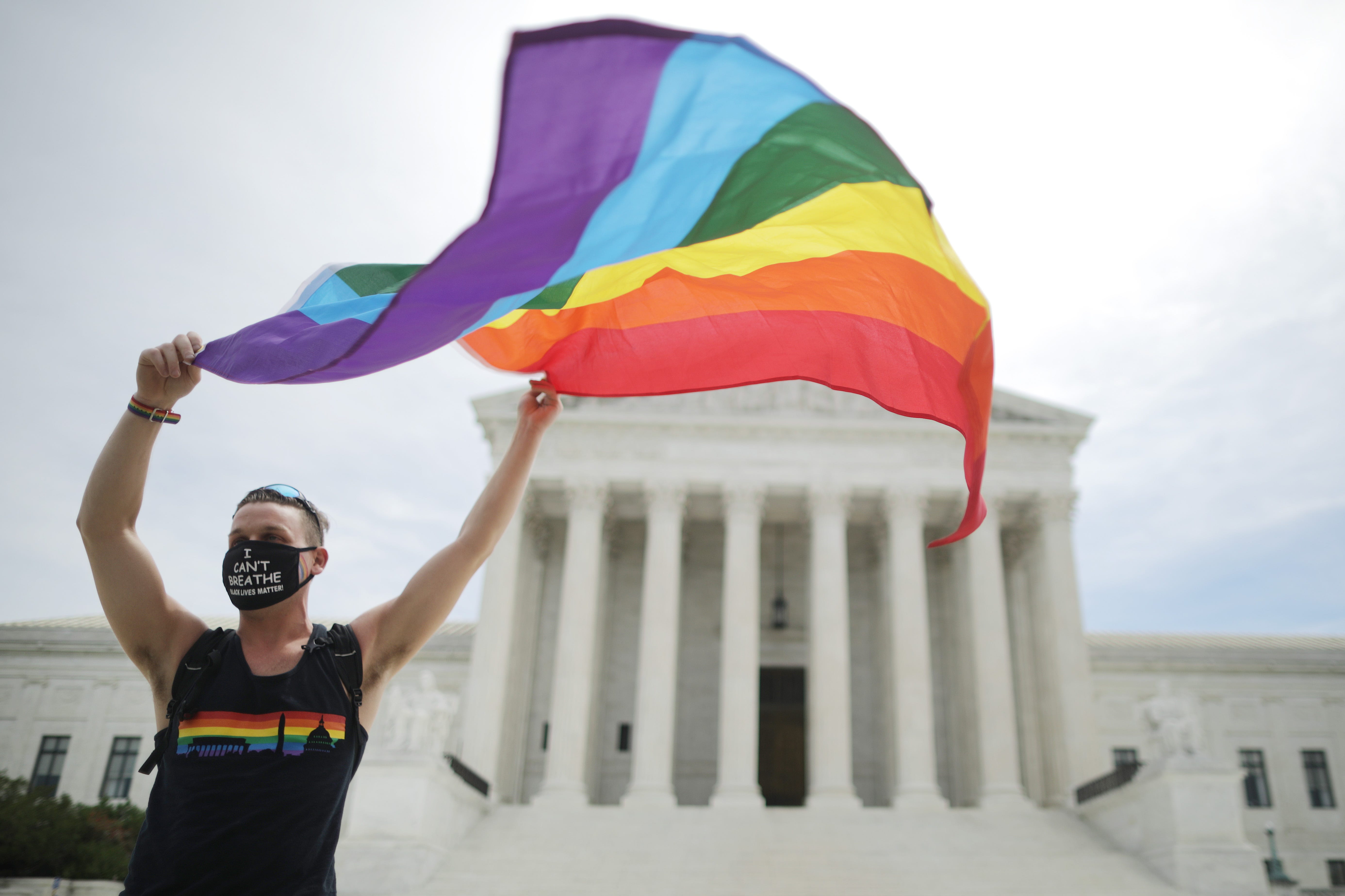 Joseph Fons holding a Pride Flag, stands in front of the Supreme Court in 2020 after the court ruled that LGBTQ+ people cannot be disciplined or fired based on their sexual orientation.