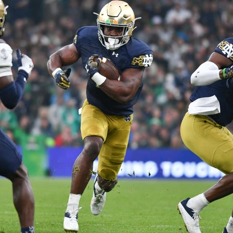 Notre Dame running back Audric Estime (7) carries the ball in the first quarter against the Navy at Aviva Stadium.
