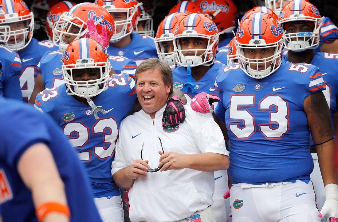 Former Florida head coach Jim McElwain, center, was reportedly offered a job as Michigan's wide receivers coach.
