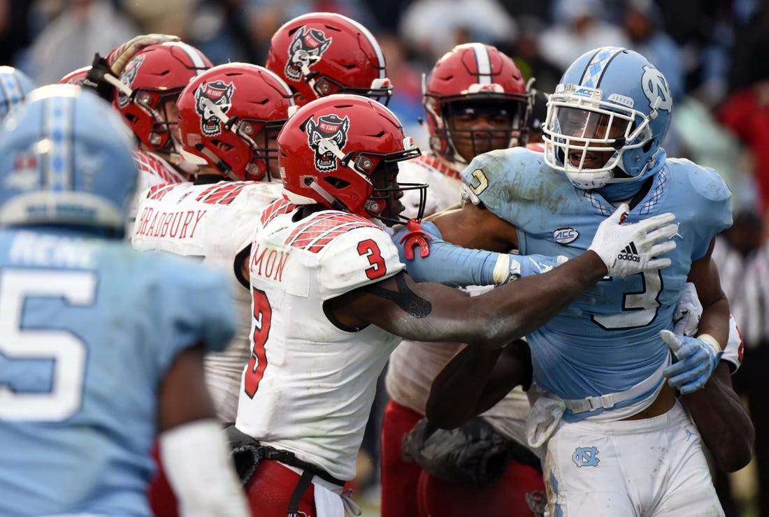 North Carolina State Wolfpack wide receiver Kelvin Harmon (3) and North Carolina Tar Heels linebacker Dominique Ross fight after a game at Kenan Memorial Stadium on Saturday.