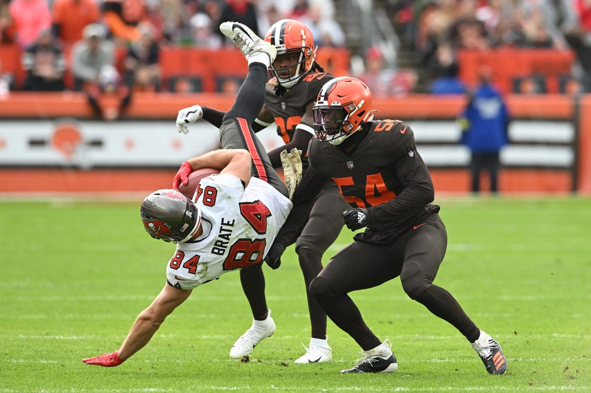 Nov 27, 2022; Cleveland, Ohio, USA; Tampa Bay Buccaneers tight end Cameron Brate (84) is tackled by Cleveland Browns cornerback Martin Emerson Jr. (23) and linebacker Deion Jones (54) during the second half at FirstEnergy Stadium. Mandatory Credit: Ken Blaze-USA TODAY Sports