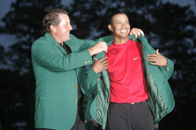 Syndication: The Augusta Chronicle - 2004 Masters champion Phil Mickelson helps 2005 winner, Tiger Woods, into his fourth green jacket on April 10, 2005.Golf 2005 Masters