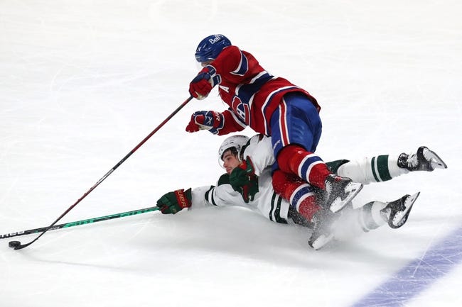 NHL: Minnesota Wild at Montreal Canadiens - Apr 19, 2022; Montreal, Quebec, CAN; Minnesota Wild left wing Kevin Fiala (22) gets a minor penalty for tripping on Montreal Canadiens center Nick Suzuki (14) during the third period at Bell Centre. Mandatory Credit: Jean-Yves Ahern-USA TODAY Sports